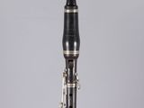 a close up of a black and gold clarinet on a clear surface