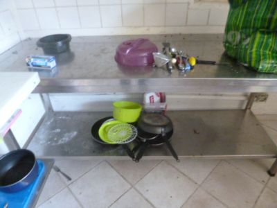 une table en acier inoxydable sur laquelle sont posés deux casseroles et poêles