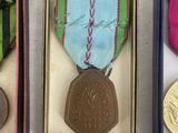 three medals are in a box on a white surface
