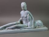 a statue of a woman sitting on the ground next to a dog