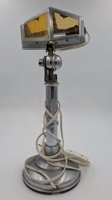 une image représentant une lampe argentée surmontée d'un abat-jour en verre