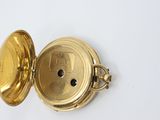 an image of a gold pocket watch on a white surface