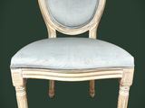 une image représentant une chaise blanche sur laquelle est posé un coussin bleu