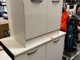 une armoire blanche à tiroirs dans un magasin où se trouvent d'autres articles