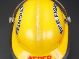 a yellow fireman ' s helmet with stickers on it