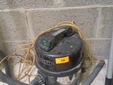 a dust collector sitting on the floor next to a wall