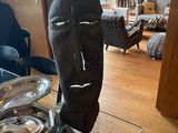 a sculpture of a face on a glass table in a living room