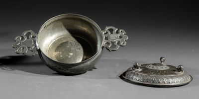 a silver cup with a lid sitting next to another cup