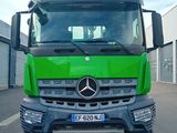 un camion vert qui roule dans la rue