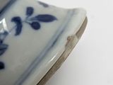 a blue and white vase on a table with a white background