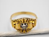 a close up of a gold ring with a diamond on it