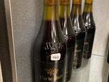 Plusieurs bouteilles de vin sont alignées sur une étagère en verre