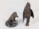 une statue représentant un oiseau et un ours, posée sur un socle en marbre