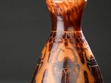 un vase posé sur une table, dont l'ombre se projette sur le sol