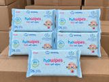 quatre paquets de lingettes pour bébé posés sur une boîte en carton