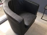une chaise noire qui se trouve dans une pièce