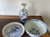 two blue and white bowls and a vase on a table