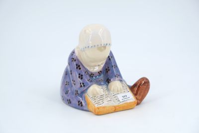 a figurine of a man reading a book
