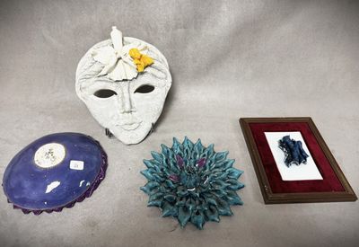 un masque blanc, un cadre photo et la photo d'une fleur posée sur une table