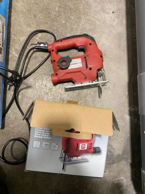 an image of a red and black corded jig saw next to a box of tools