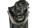 sculpture of a man ' s head with a cigarette in his mouth