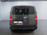 the back of a grey van is parked in a garage