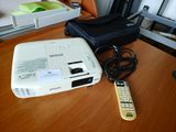un petit projecteur posé sur une table à côté d'une télécommande