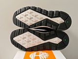 a close up of a pair of shoes on top of an orange and white box