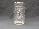 a glass jar with a skull on it sitting on a table