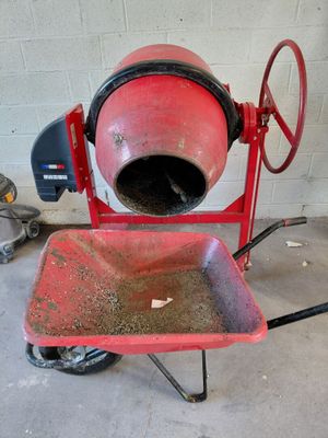 une bétonnière rouge posée sur un chariot dans un garage