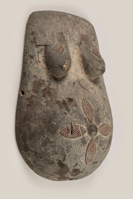 une image représentant un masque en pierre sur un mur