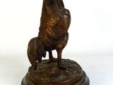 statue en bronze représentant un chien et un coq, posée sur un socle en marbre
