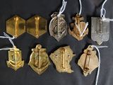 several different types of medals are displayed on a black surface