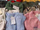 a pile of sweaters with price tags on them