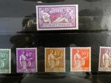 six different stamps on display in a glass case