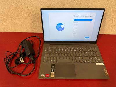 a laptop computer sitting on a red table with a charger