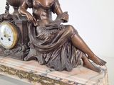 a statue of a woman sitting on a table with a clock