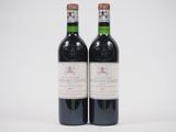 deux bouteilles de vin posées l'une à côté de l'autre sur une surface blanche