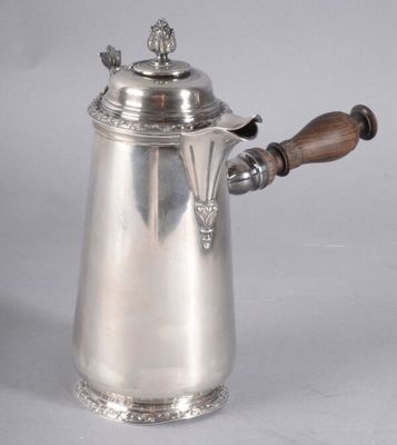 une cafetière ancienne en argent avec une poignée en bois sur fond blanc