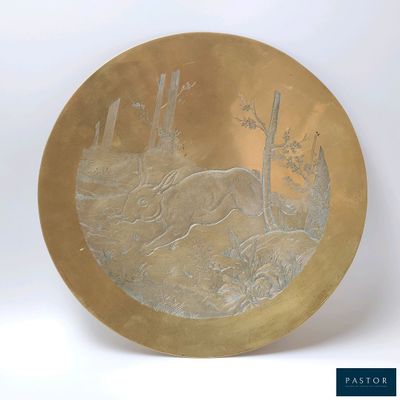 une assiette en or ornée d'un cerf dans les bois