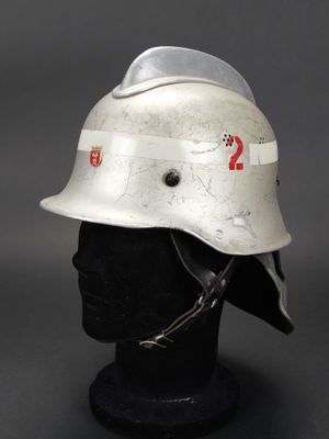 un vieux casque de pompier posé sur une tête de mannequin noire