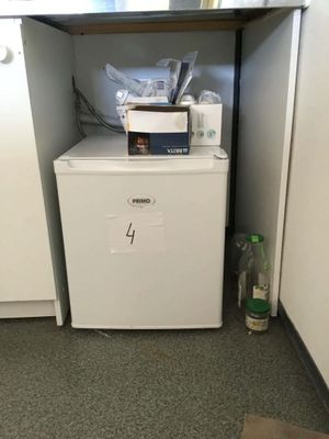 a small refrigerator in the corner of a kitchen