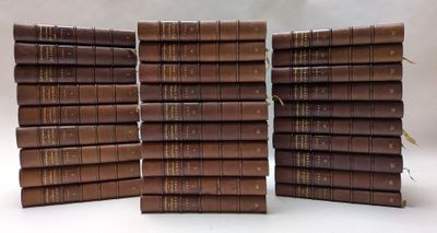 plusieurs livres marron empilés les uns sur les autres sur une surface blanche