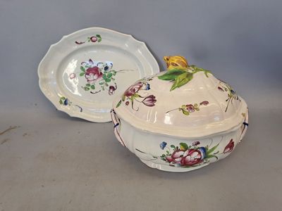 deux assiettes et un bol avec un couvercle posés sur une table