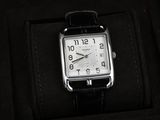 une photo d'une montre dans un coffret, avec un bracelet noir