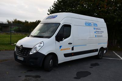 une camionnette blanche garée dans un parking