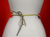 a white mannequin torso with a yellow and pink belt