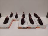 Six paires de chaussures marron sont exposées dans une vitrine.