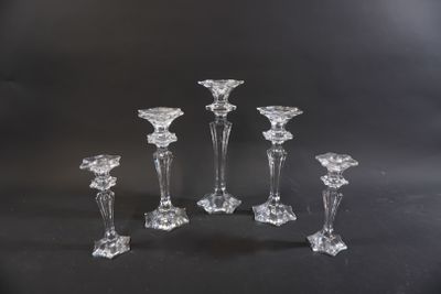 five clear glass candlesticks sitting on a black surface