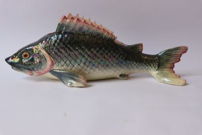 une figurine de poisson posée sur une surface blanche